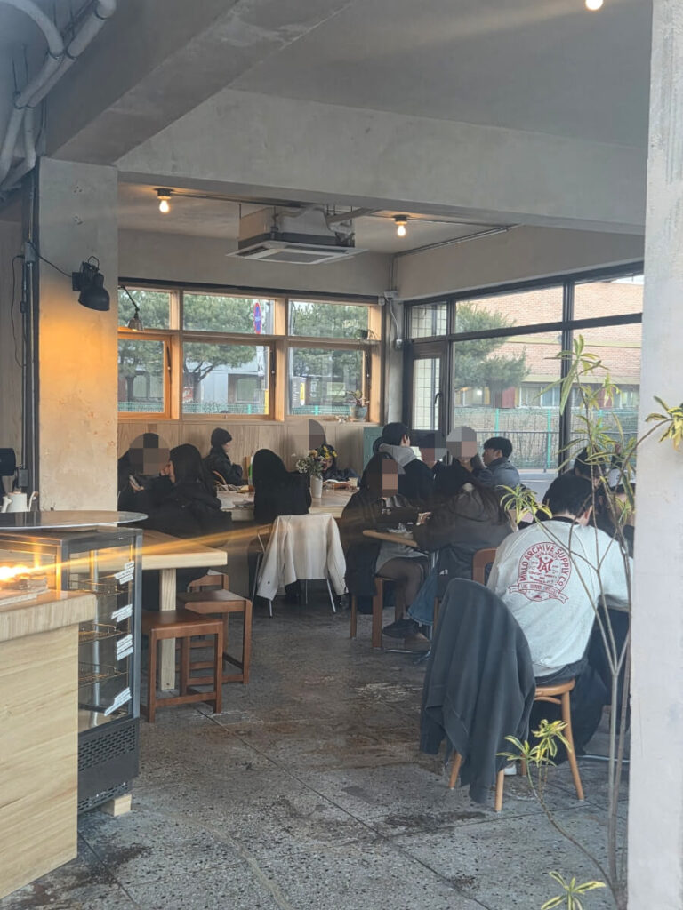 Inside the café, you can see a mix of table seating and the open roasting area. The roasting machine is placed in view