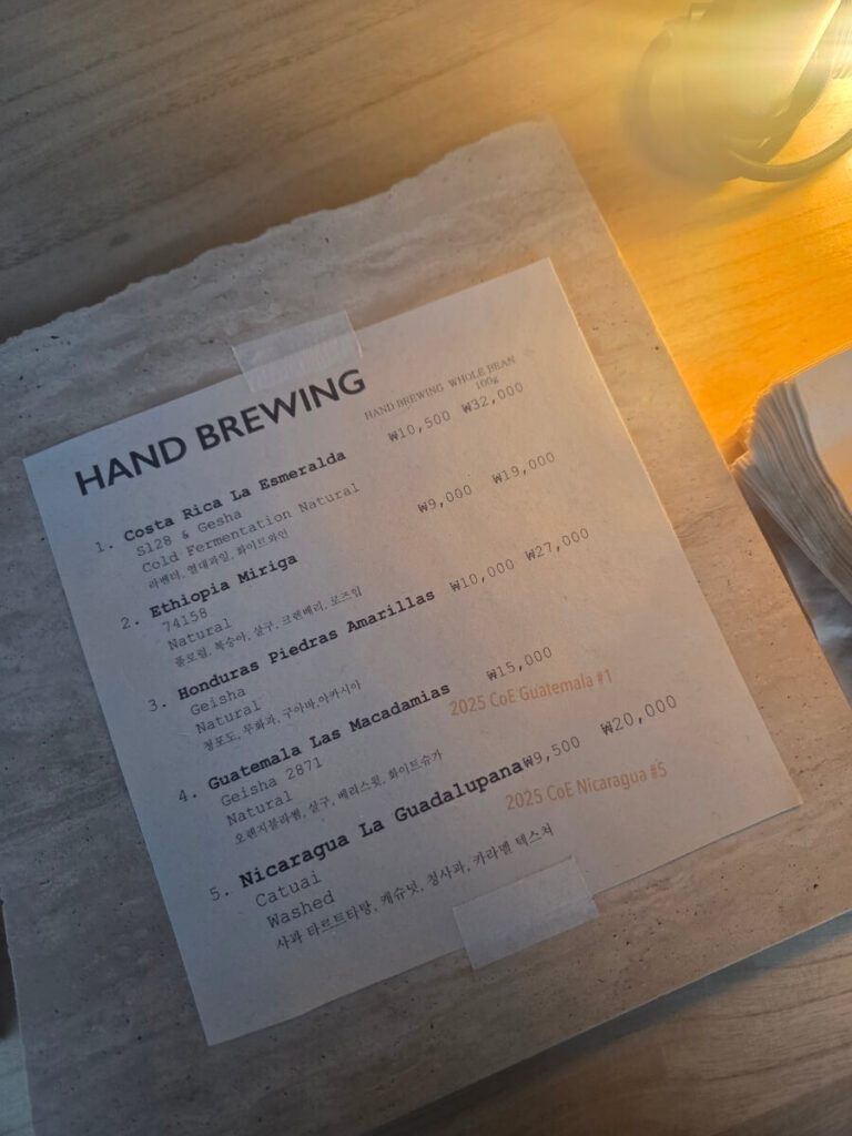 The hand-drip coffee menu, presented like a tasting note sheet. Each bean comes with detailed flavor descriptions similar to wine tasting notes, adding depth to the coffee experience.