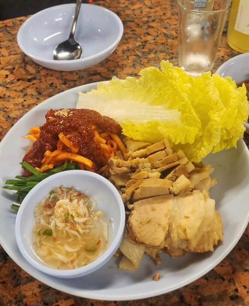 tender slices of Korean boiled pork (Bossam) served with kimchi.