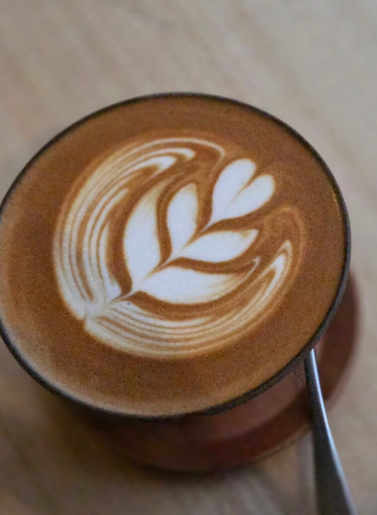 A flat white served with clean latte art at Always August Roastery.