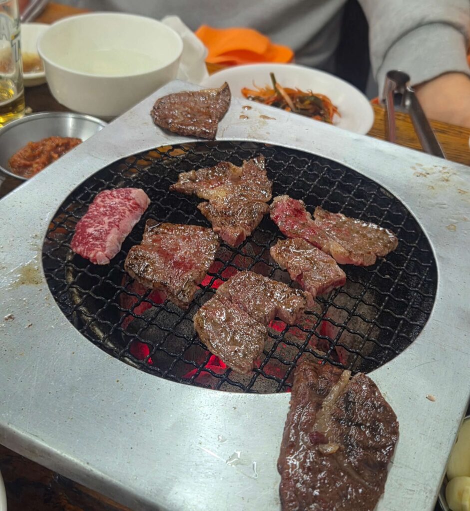 1++ Hanwoo ribeye grilling over real charcoal at Sanbul Deungsim — the best Myeongdong Hanwoo BBQ experience