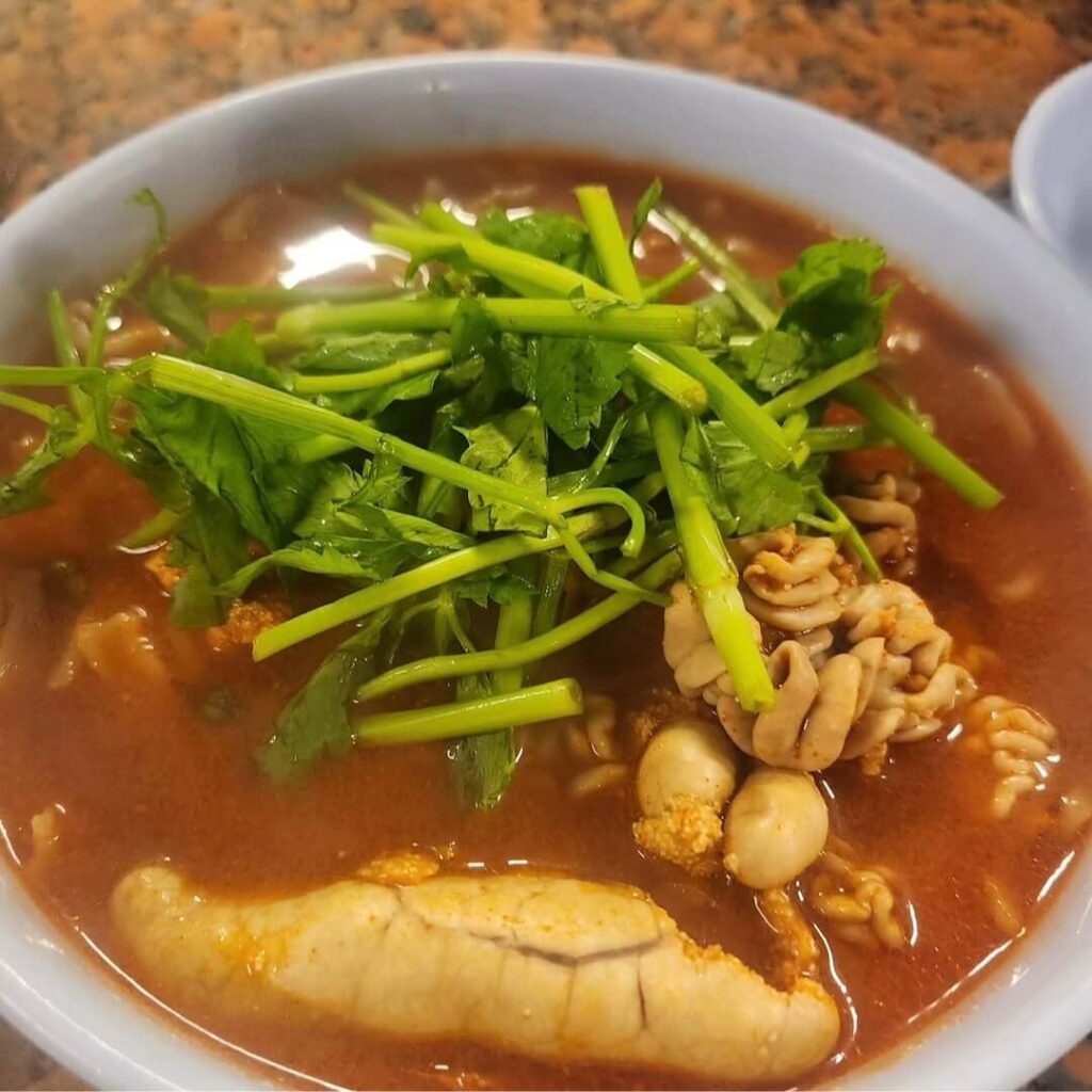 A bowl of spicy kalguksu topped with generous fish roe and milt.