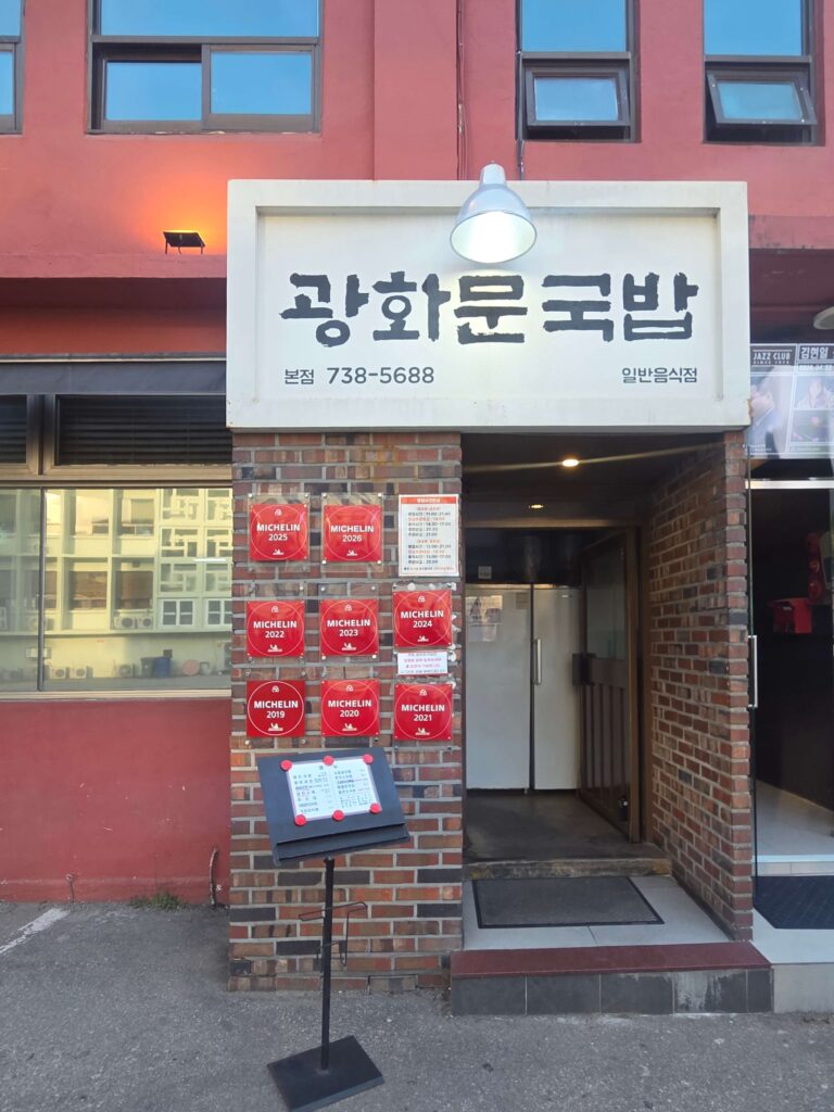 Entrance of Gwanghwamun Gukbap showcasing multiple Bib Gourmand Seoul stickers