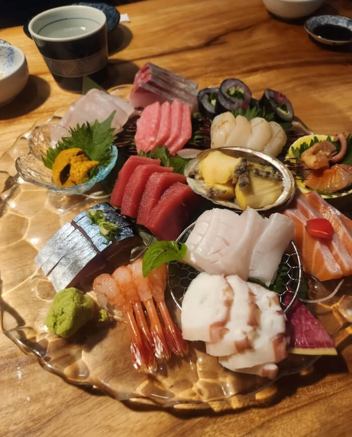 A generous selection of fresh seasonal seafood including herring, saury, sweet shrimp, uni, abalone, and scallops.