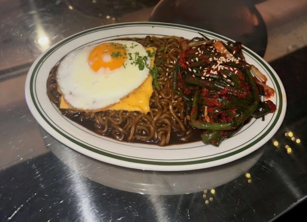 Jjagechi with egg and cheese on top of black bean noodles.
A rich and iconic Korean instant noodle variation.