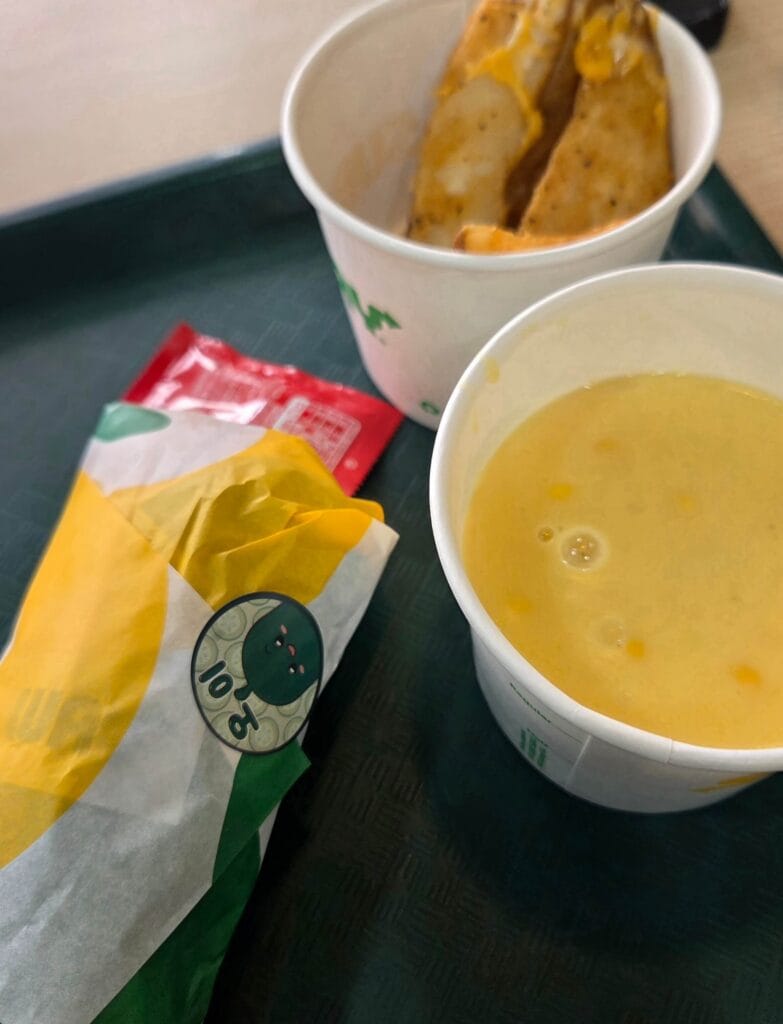 A combo meal featuring a Subway Cucumber Sandwich, corn soup, and potato wedges
