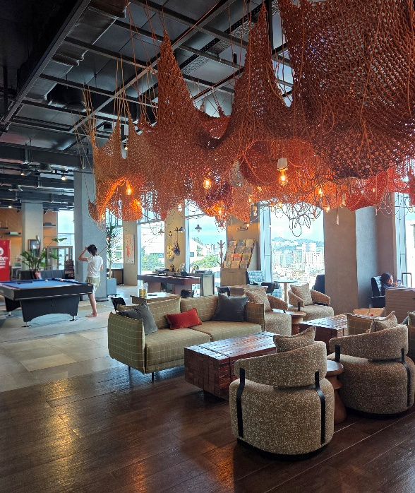 L7 Hongdae hotel lobby lounge with pool table, PC gaming room, and city-view sofa seating