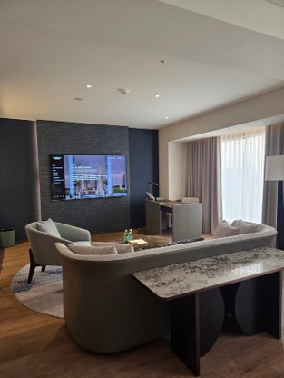a spacious, elongated rectangular layout with a living area in front of the king bed