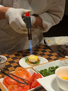 Eggs Benedict topped with caviar, made fresh by the chef on the spot