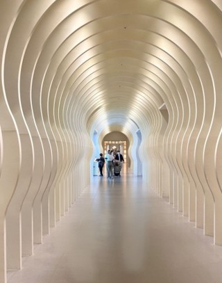 An art gallery-like hallway leading from the hotel to the lobby